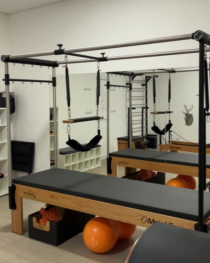 Cadillac de pilates e bolas laranja na sala