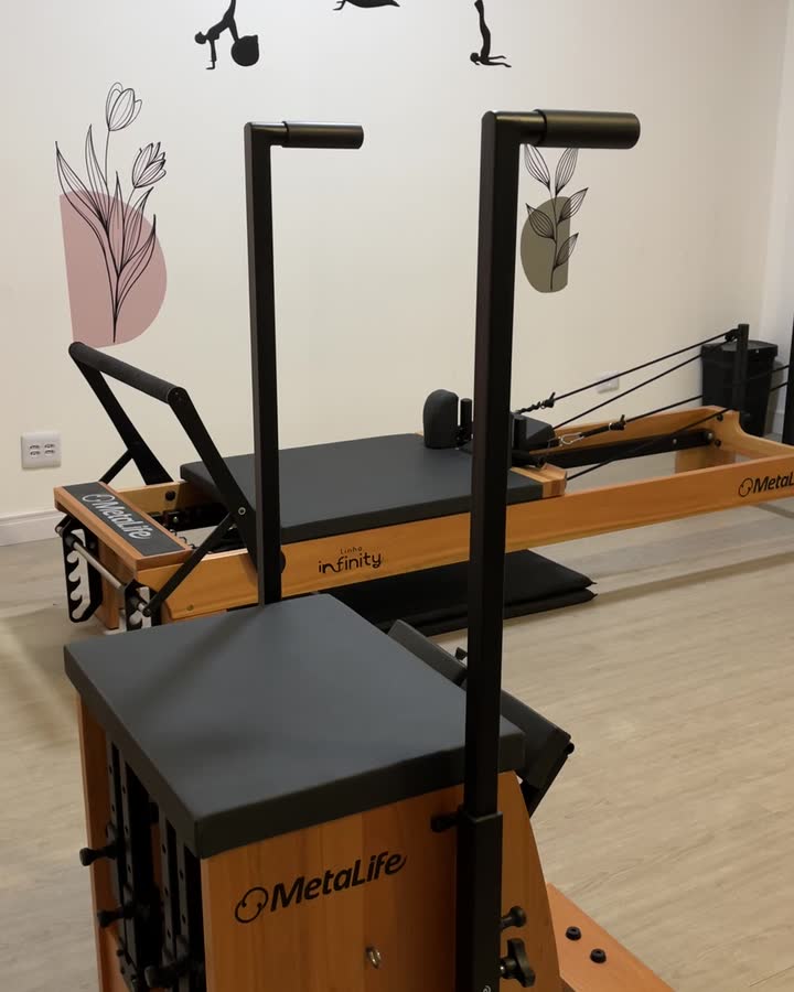 Cadeira de pilates e reformer na sala clara